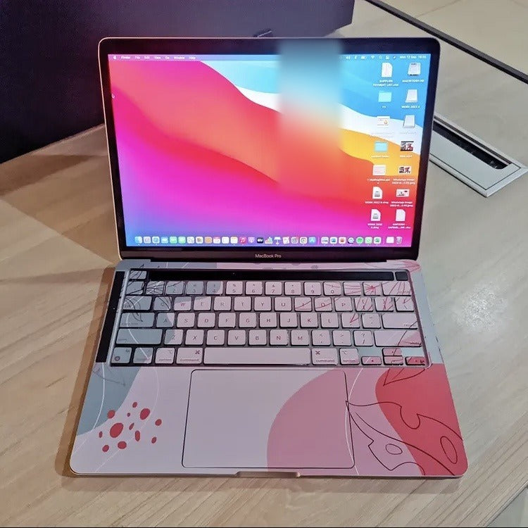 Blush Botanical laptop skin on a MacBook keyboard