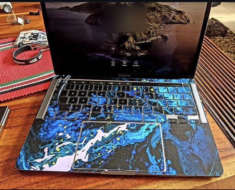 Deep Blue Fluid laptop skin on a MacBook keyboard