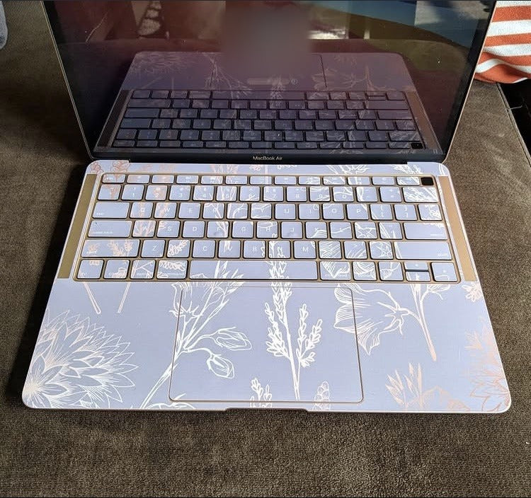 Lilac Line Botanical laptop skin on a MacBook keyboard